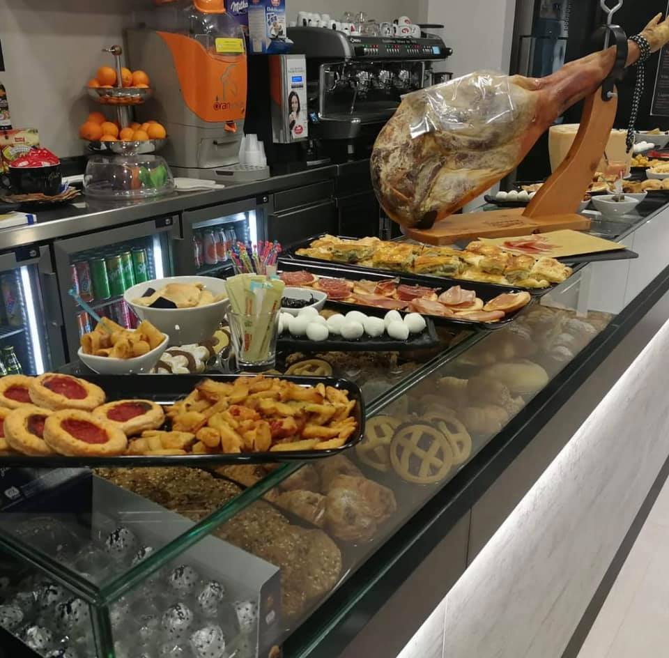 Bancone con assortimento di cibi e bevande in un bar moderno, design by Agape Arredo Bar