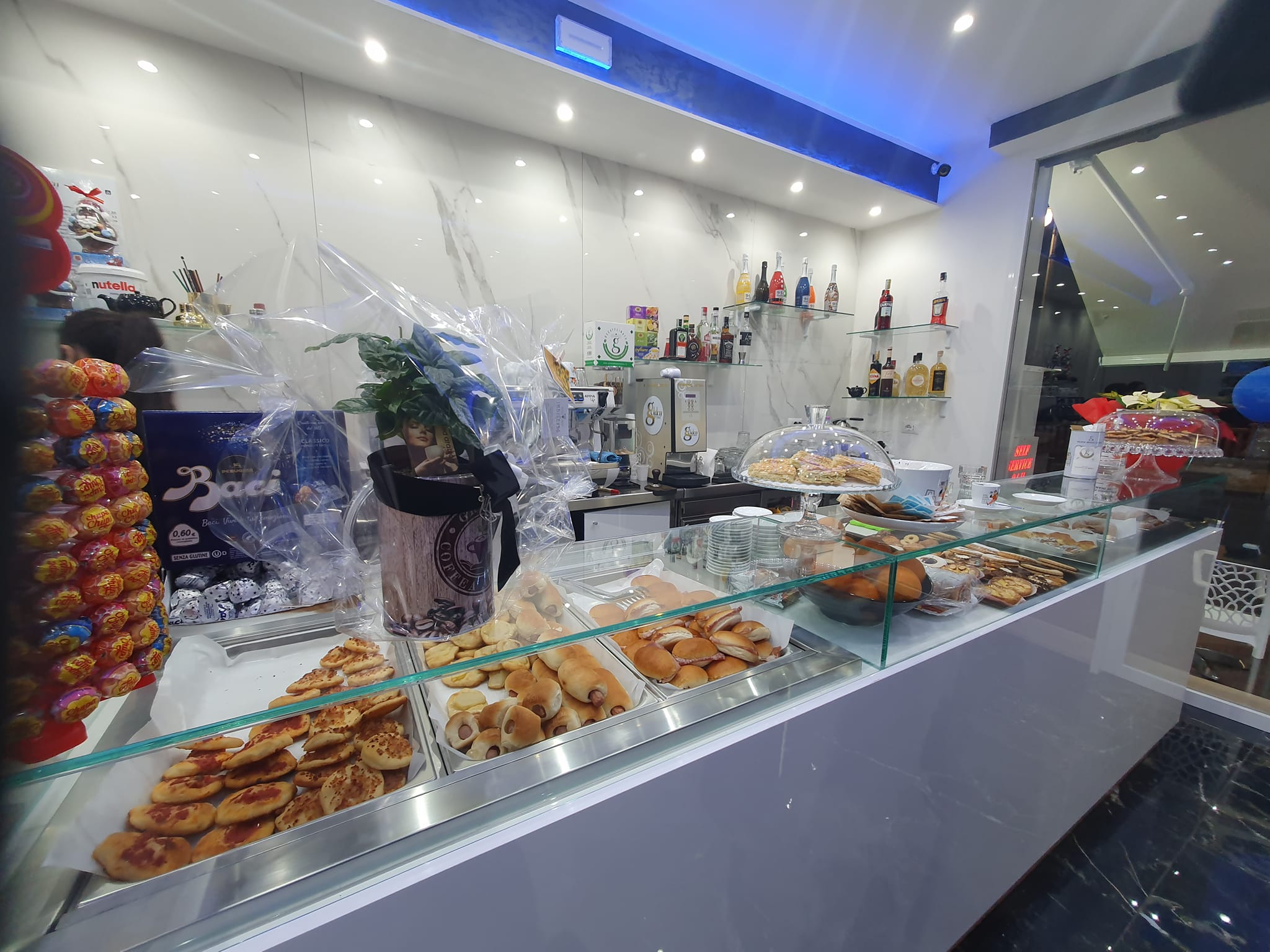 Vetrina pasticceria all'interno del locale con dolci assortiti e illuminazione moderna