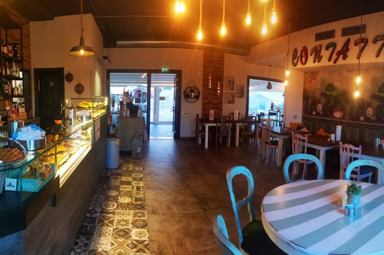 Interno del locale Contai&ograve; Caffetteria Bistr&ograve; con bancone pasticceria, tavoli e sedie in legno, illuminazione accogliente