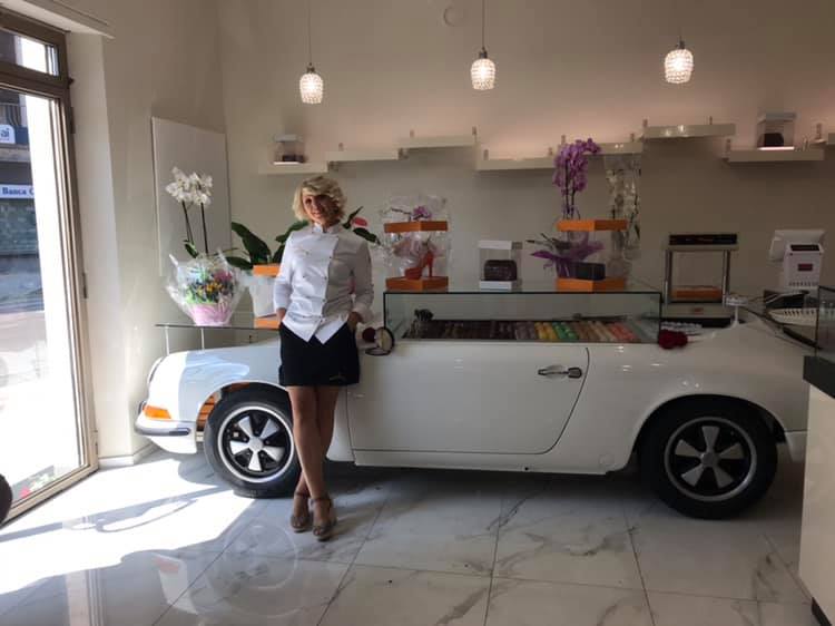 Interno del locale con bancone a forma di auto bianca e persona accanto, decorazioni eleganti e illuminazione sospesa