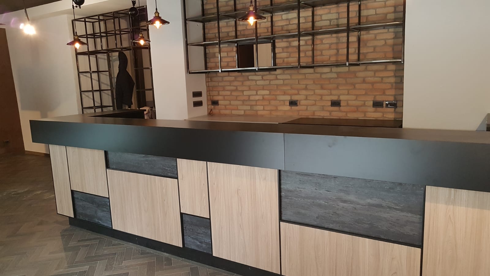 Vista ampia del cocktail bar stile industriale con pannelli rettangolari finiture legno chiaro e scuro, realizzato da Agape Arredo Bar