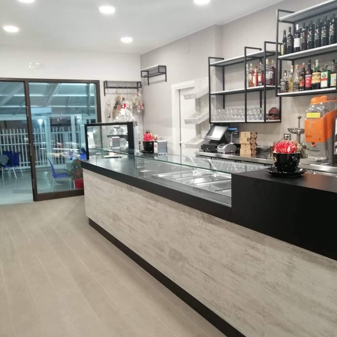 Bancone moderno in un bar con vetrina alimentare, design by Agape Arredo Bar